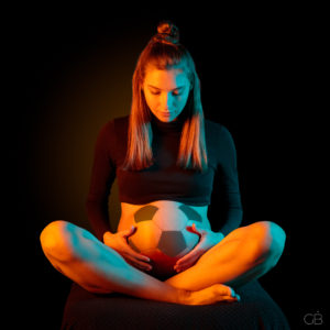 pregnant woman with football tummy, conceptual photo